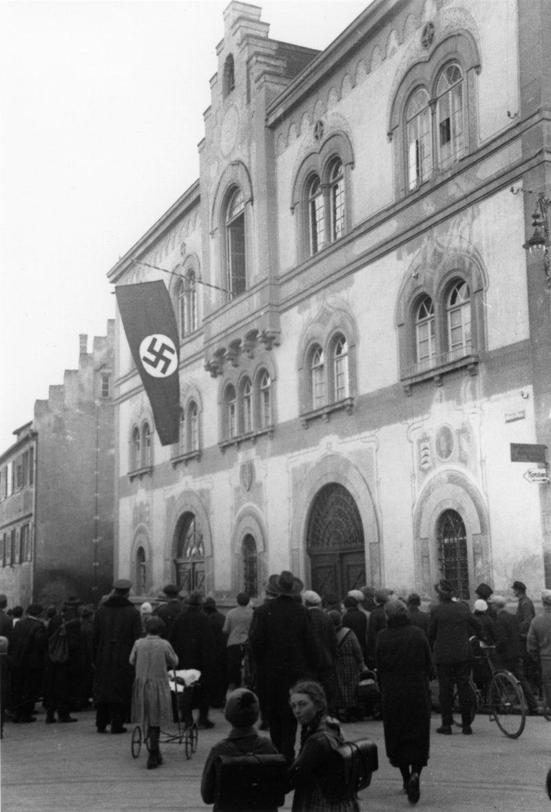 Historisches Foto: Menschenmenge vor Gebäude mit Hakenkreuzfahne. NS-Zeit.