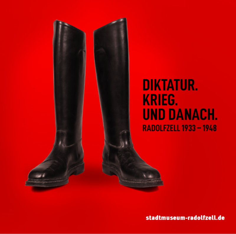 Diktatur Ausstellung: Historische schwarze Reitstiefel auf rotem Grund. Krieg und danach, Radolfzell 1933-1948.