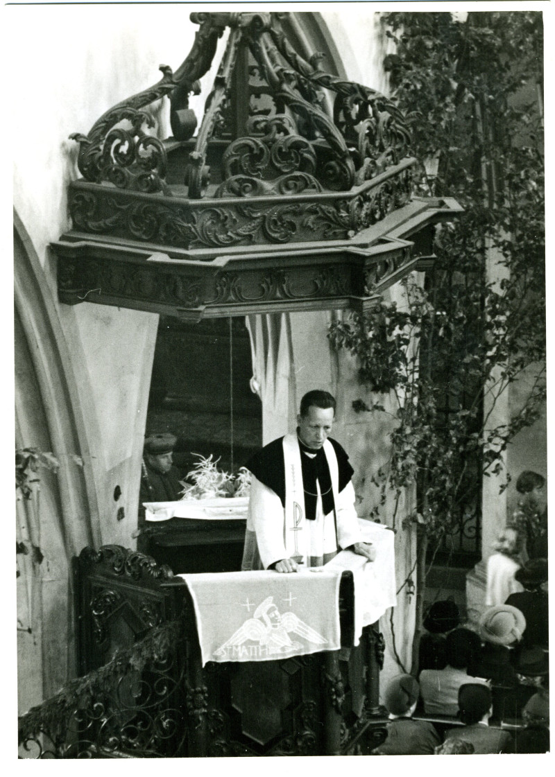 Historisches Foto: Pfarrer predigt in Kirche von kunstvoller Kanzel zu Gemeinde. Vintage Schwarzweißaufnahme.